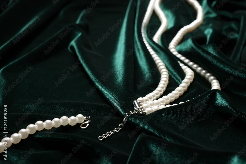 Fototapeta premium Beautiful pearl necklace on green cloth, closeup