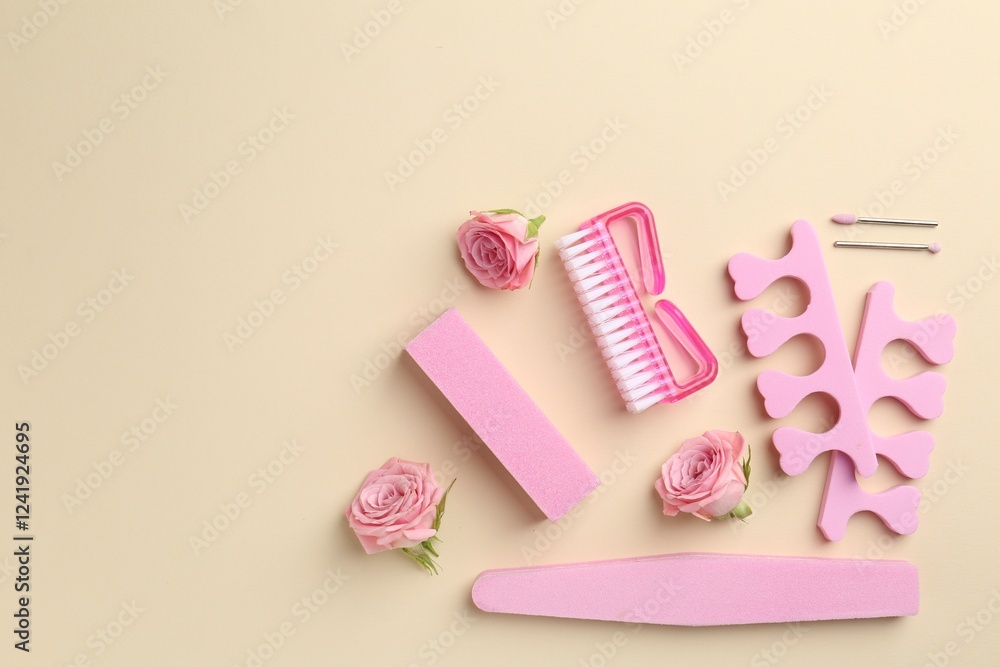 Set of pedicure tools and flowers on beige background, flat lay. Space for text Set of pedicure tools and flowers on beige background, flat lay. Space for text