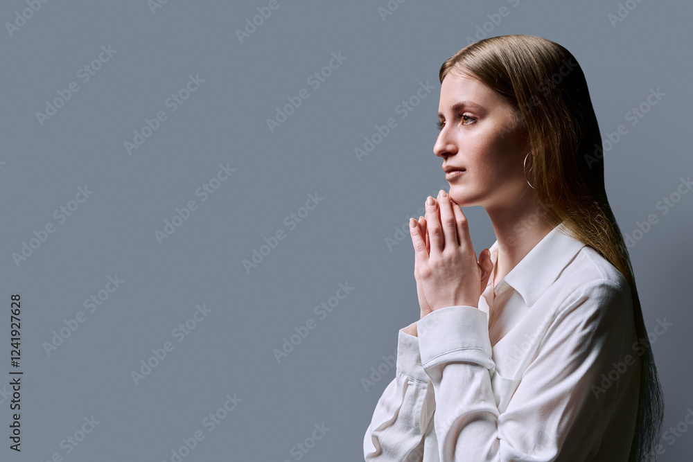 Profile view, serious young woman, copy space gray studio background Profile view, serious young woman, copy space gray studio background
