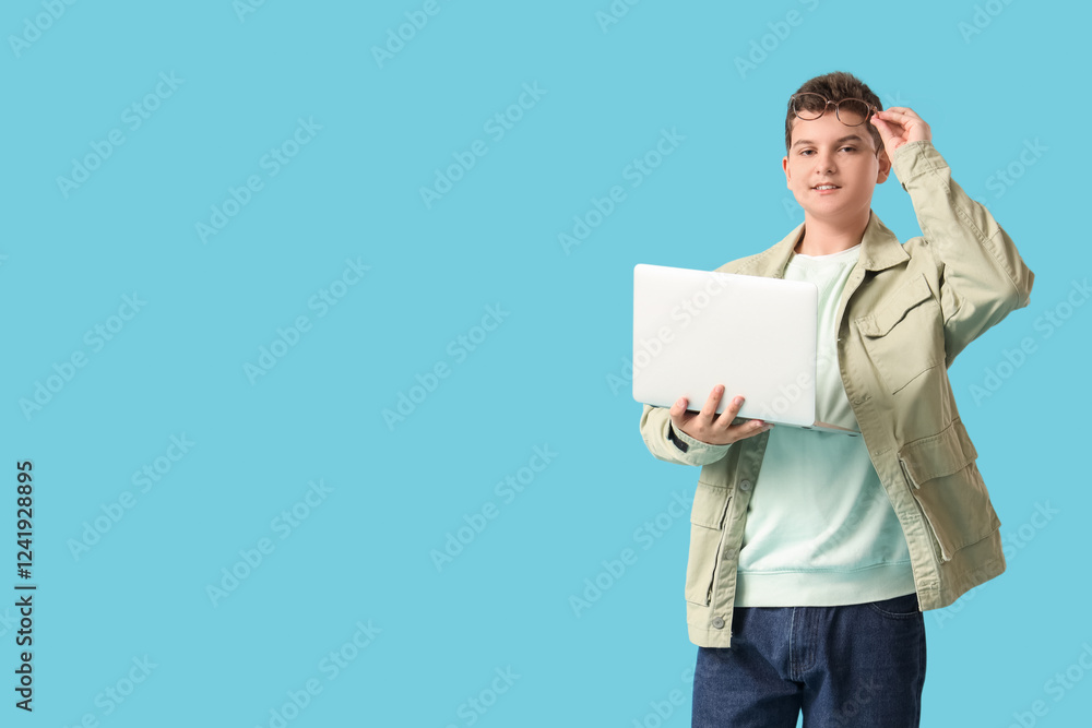 Teenage programmer with eyeglasses and laptop on blue background Teenage programmer with eyeglasses and laptop on blue background