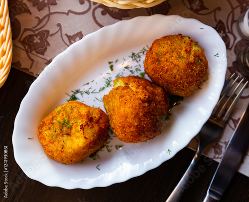 National dish of Belarus - deep-fried pyzy (potato dumplings) with mushroom stuffing garnished with greens.. photo