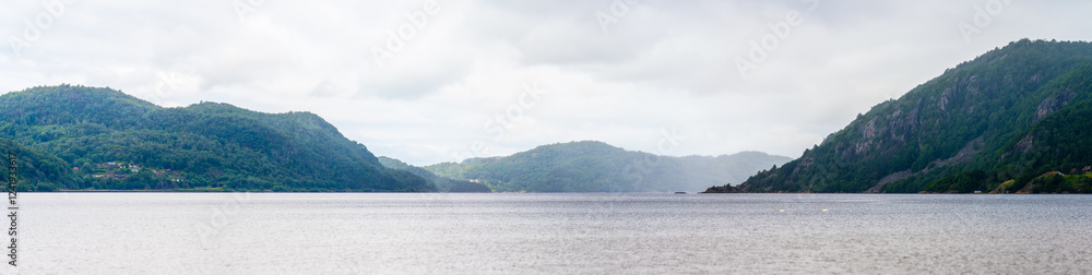 scenic panorama of a misty fjord with green hills. scenic panorama of a misty fjord with green hills.