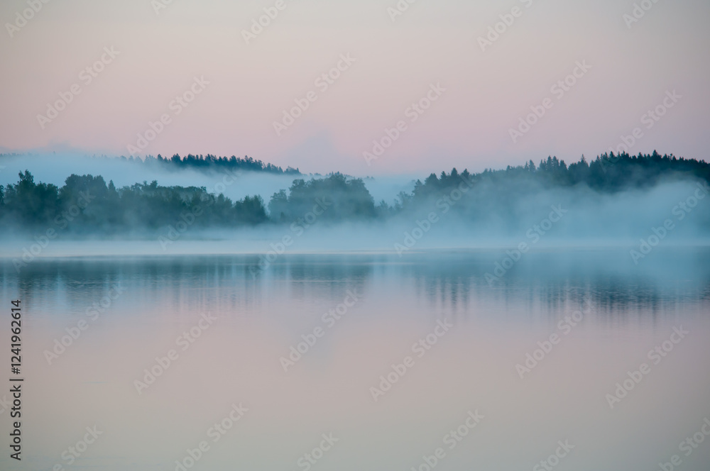 Fototapeta premium Early summer night by a calm lake in Finland with fog rising from the water