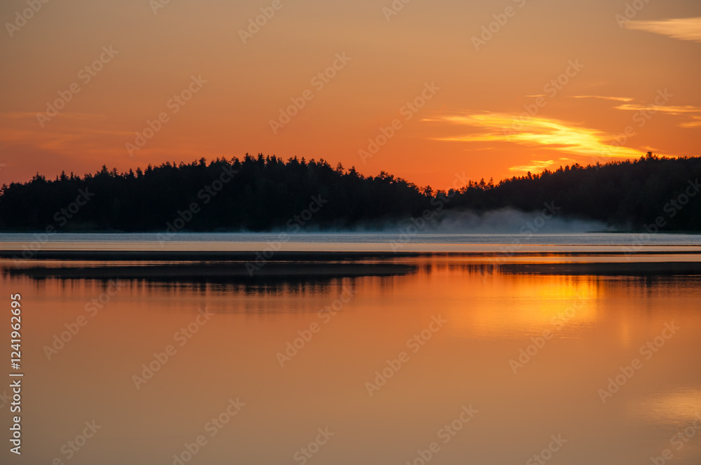 Early summer night by a calm lake in Finland with fog rising from the water Early summer night by a calm lake in Finland with fog rising from the water