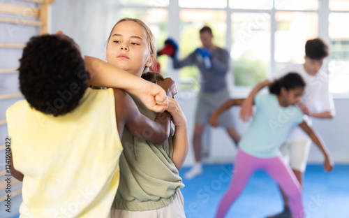 Preteen children pairs learning strength self-defense in the gym photo