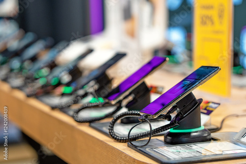 Showcase with smartphones in the modern electronics store. Buy a mobile phone. Many smartphones on the shelf of the technology store photo