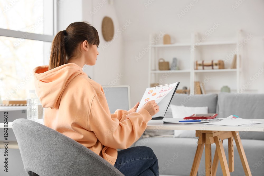Teenage girl with diagrams working online at home Teenage girl with diagrams working online at home