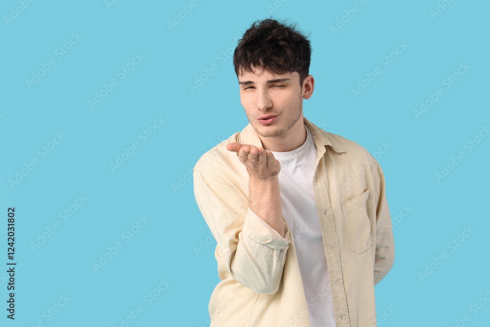 Handsome young man blowing kiss on blue background Handsome young man blowing kiss on blue background