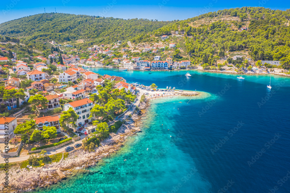 Naklejka premium A breathtaking aerial view of Stomorska Bay on Solta Island, Croatia, showcasing its deep sunlit cove, crystal-clear Adriatic waters, beautiful beaches, and lush Mediterranean scenery.