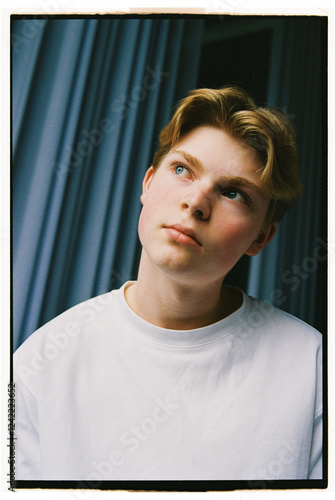 Young person with thoughtful expression in casual attire indoors photo