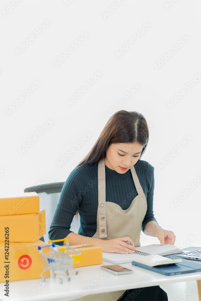 Online SME Business Ideas Starting a Small Business SME business owner Asian female entrepreneur works on receipt boxes and checks online orders to prepare boxes to sell to customers. Vertical image. Online SME Business Ideas Starting a Small Business SME business owner Asian female entrepreneur works on receipt boxes and checks online orders to prepare boxes to sell to customers. Vertical image.