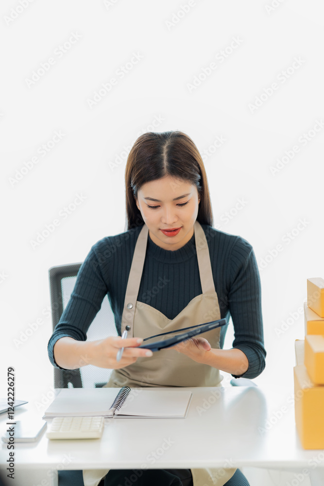 Online SME Business Ideas Starting a Small Business SME business owner Asian female entrepreneur works on receipt boxes and checks online orders to prepare boxes to sell to customers. Vertical image. Online SME Business Ideas Starting a Small Business SME business owner Asian female entrepreneur works on receipt boxes and checks online orders to prepare boxes to sell to customers. Vertical image.