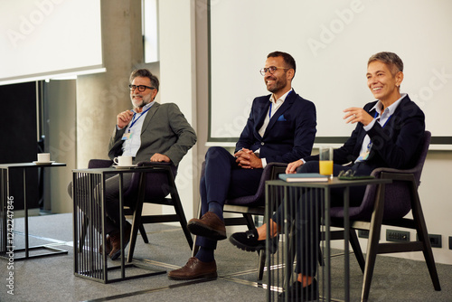 Businesspeople speak on stage photo