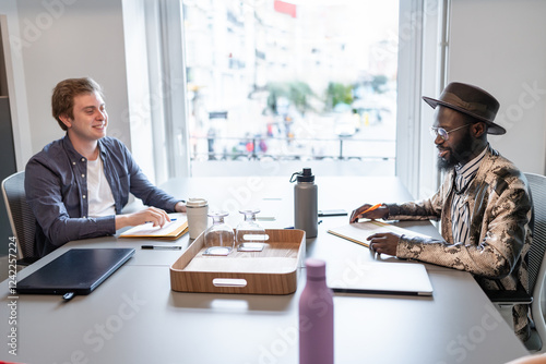 Two businessmen working together in modern coworking space photo