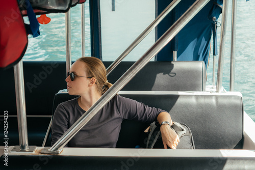 Woman enjoying a boat ride on a sunny day near the coast photo