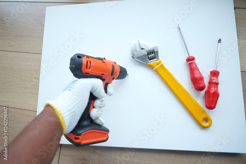 Wallpaper Mural Hand holding power drill and tools on flat surface for DIY project Torontodigital.ca