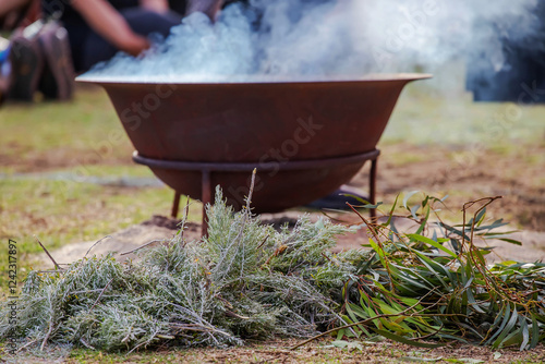 Ritual fire with green branch of eucalyptus, smoke and fire, the ritual rite at a indigenous community event in Australia