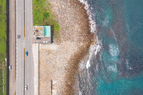 Aerial View of Coastal Rocks and Building Near Ocean photo