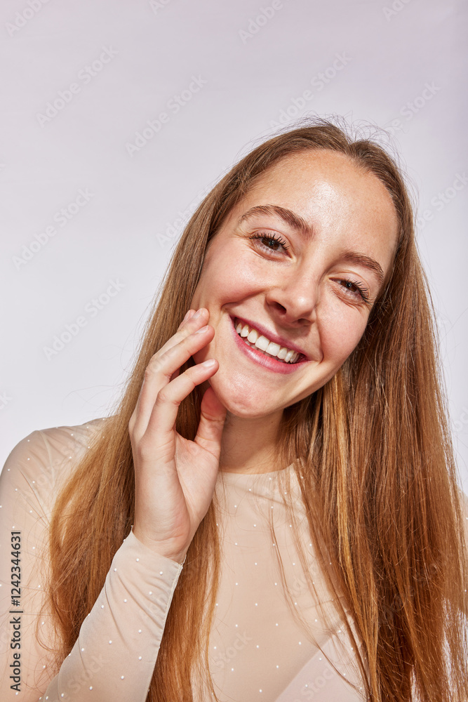 Smiling woman touching face in studio Smiling woman touching face in studio