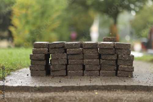 Pile of bricks is sitting on a sidewalk photo