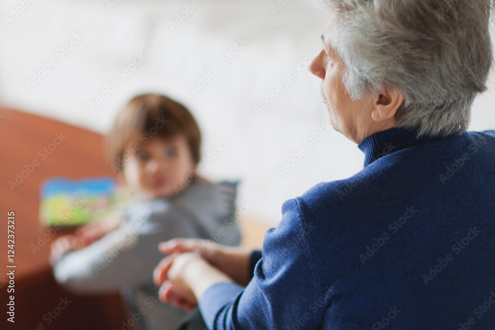 Elderly woman interacts with child in cozy indoor setting Elderly woman interacts with child in cozy indoor setting