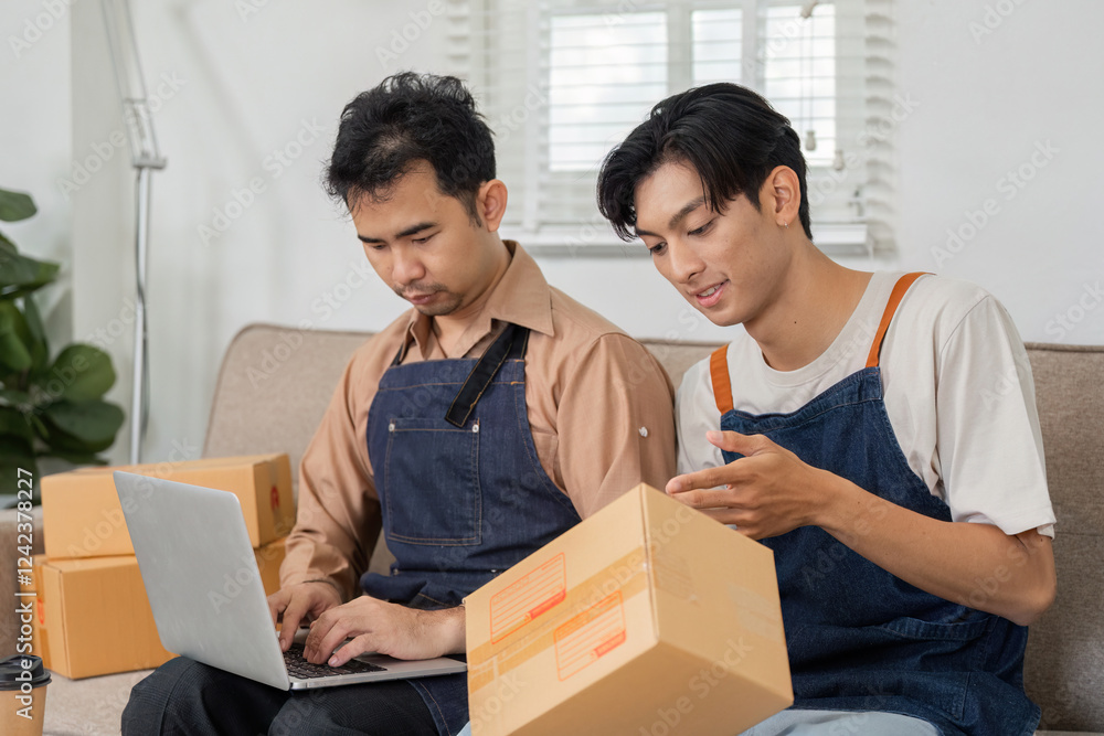 Two young delivery professionals discussing packages in a cozy office space with a laptop Two young delivery professionals discussing packages in a cozy office space with a laptop