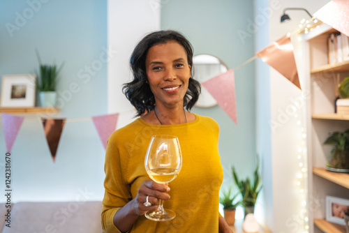 Smiling guest holding a wine glass at festive celebration photo