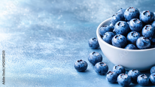 Fresh blueberries in white bowl on blue background, vibrant and healthy