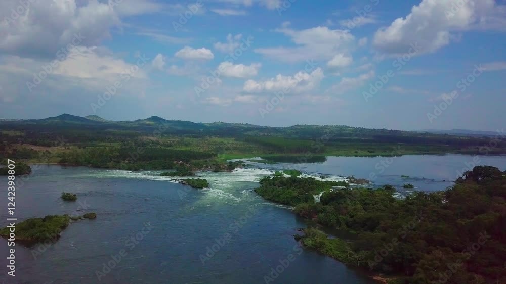 Aerial view of the source of the Nile River with its rapids and waterfalls flowing through the green lush landscape of Uganda, Africa, under a cloudy sky Aerial view of the source of the Nile River with its rapids and waterfalls flowing through the green lush landscape of Uganda, Africa, under a cloudy sky