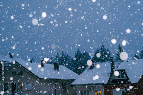 Winter landscape with snowfall and cozy tiled roofs of houses 