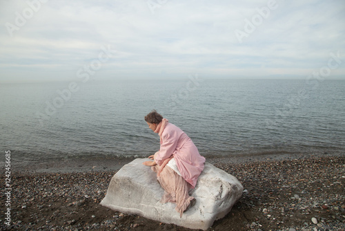 A girl on the stone at the sea  photo