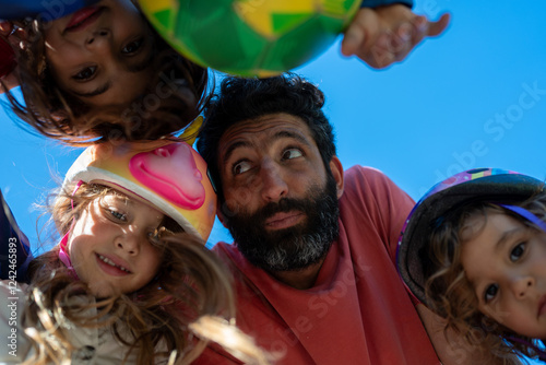 A father at the park with his kids head to head for a photo