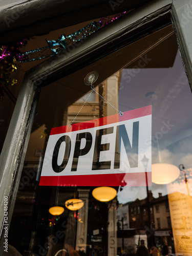 Open sign on a glass door in a cozy London street scene photo