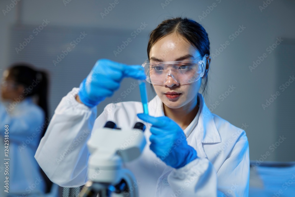 Scientist analyzing blue liquid in test tube in laboratory Scientist analyzing blue liquid in test tube in laboratory