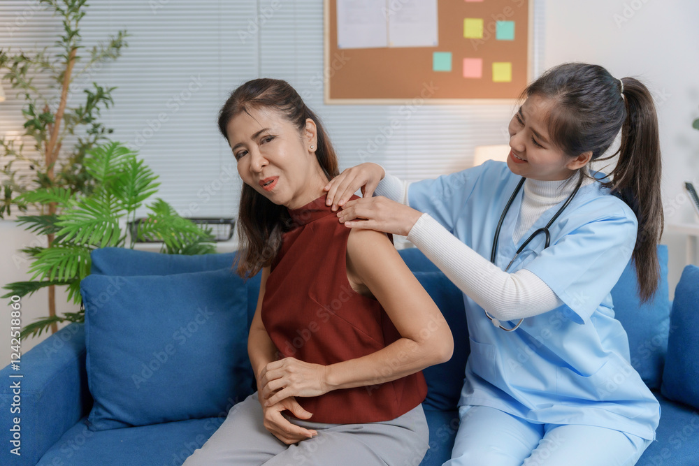 Fototapeta premium Doctor examining senior woman shoulder pain at home visit