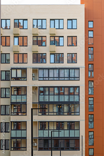 Modern apartment building facade with balconies and large windows in urban setting