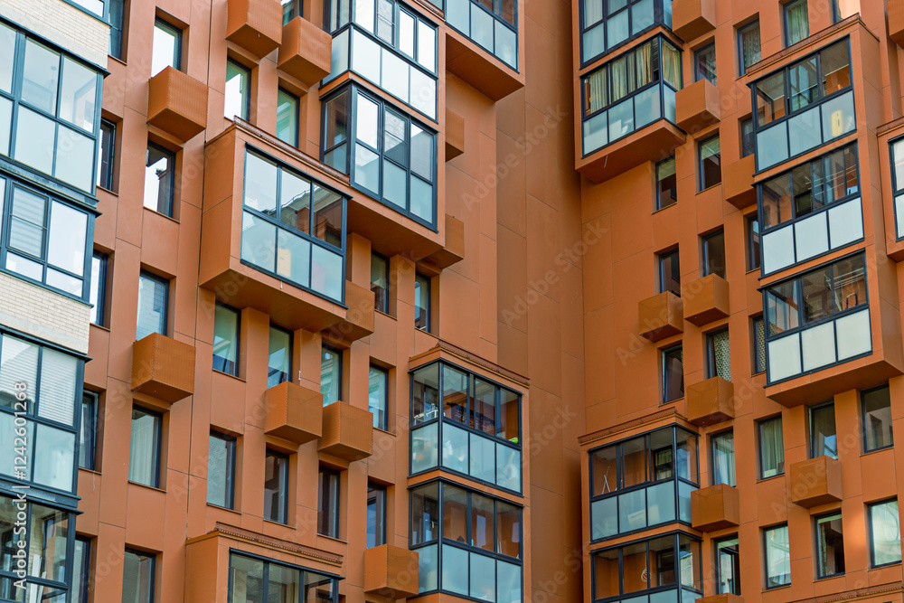 Stylish apartment building with orange panels and modern balconies in urban district Stylish apartment building with orange panels and modern balconies in urban district