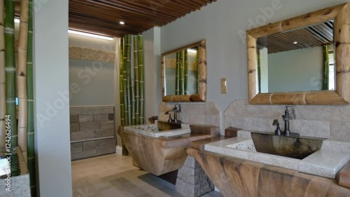 A washroom featuring natural stone sinks, bamboo accents, and a soft water feature for a calming vibe.
