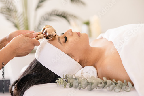 Slika na platnu Women having ice globe massage on head