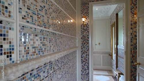A luxurious bathroom with intricate mosaic tiles covering the walls, combined with understated gold or chrome fixtures.