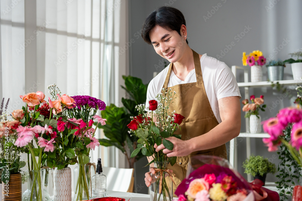 Asian handsome florist man completing beautiful bouquet in flower shop. Asian handsome florist man completing beautiful bouquet in flower shop.