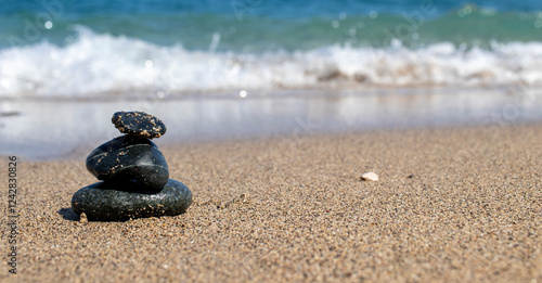 Canvas Print black stones on the beach, sea and waves.zen stones