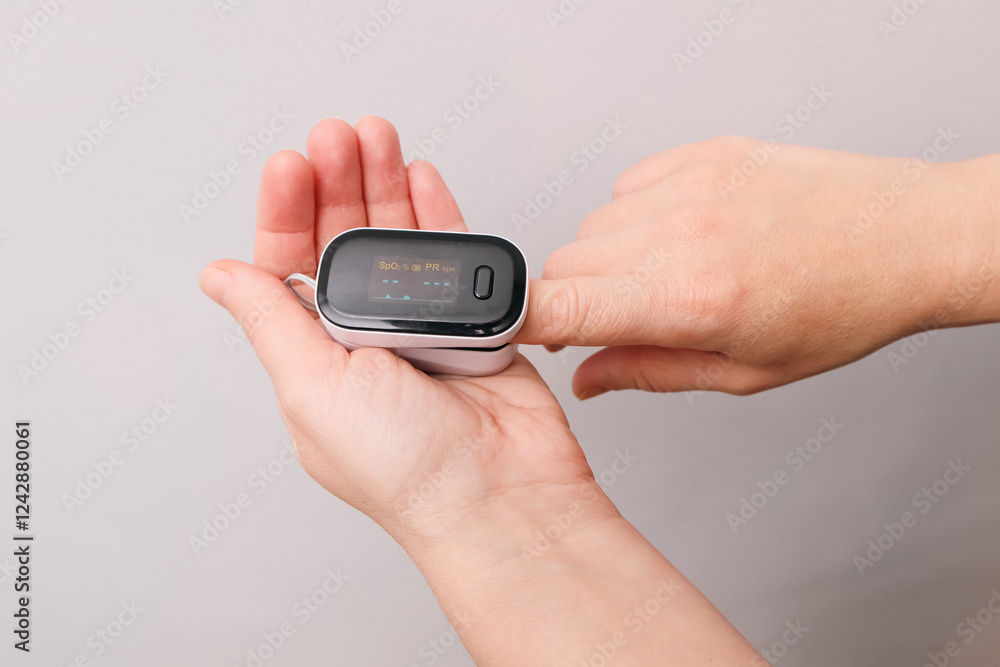 A woman checking her heart rate and oxygenation level. Monitoring Blood Oxygen Levels and Pulse Rate A woman checking her heart rate and oxygenation level. Monitoring Blood Oxygen Levels and Pulse Rate