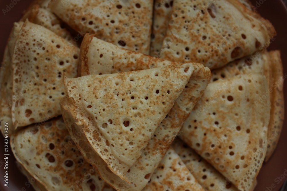 baked pancakes openwork in a hole triangles close-up baked pancakes openwork in a hole triangles close-up