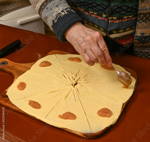 Obraz na płótnie Baking tradition with dough and fruit filling in a cozy kitchen setting during winter w salonie