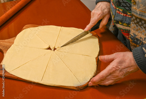 Obraz na płótnie Homemade dough being cut into equal pieces for pastry preparation in a cozy kitchen setting w salonie