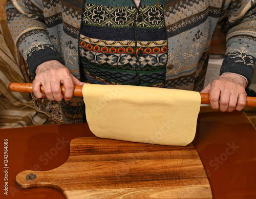Obraz na płótnie Homemade pasta preparation with a wooden rolling pin by a skilled cook in a cozy kitchen at midnight w salonie