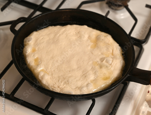 Obraz na płótnie Dough rising in a cast iron skillet over a gas stove during meal preparation on a warm afternoon w salonie