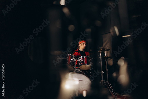 Young Drummer With Red Bandana Playing Drums in a Dark Music Studio
