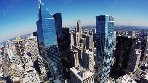 Comcast technology center and center city district are rotating, showcasing philadelphia's modern architectural landscape and urban density under a clear blue sky photo